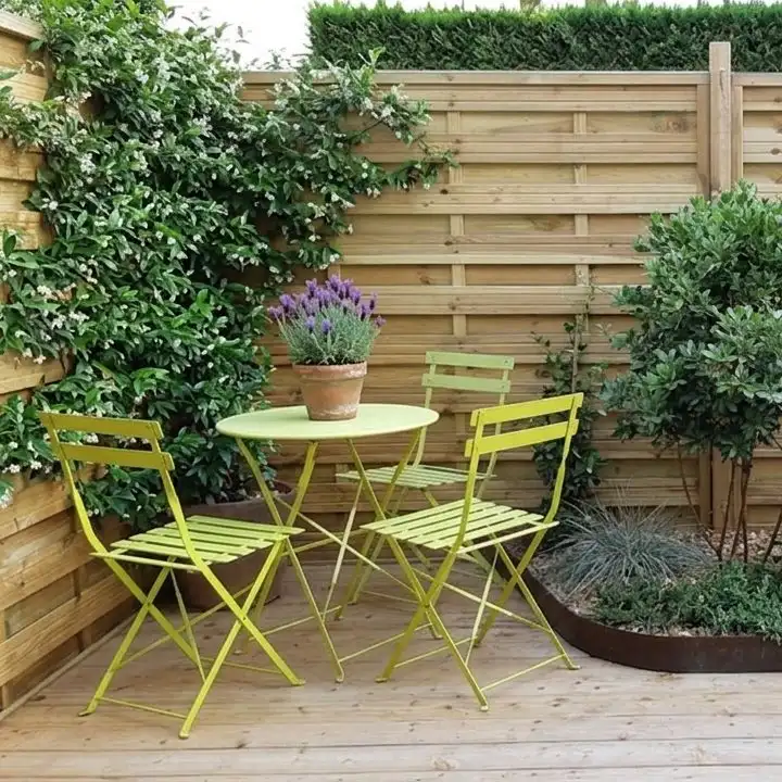 Small terrace with green chairs and potted plants