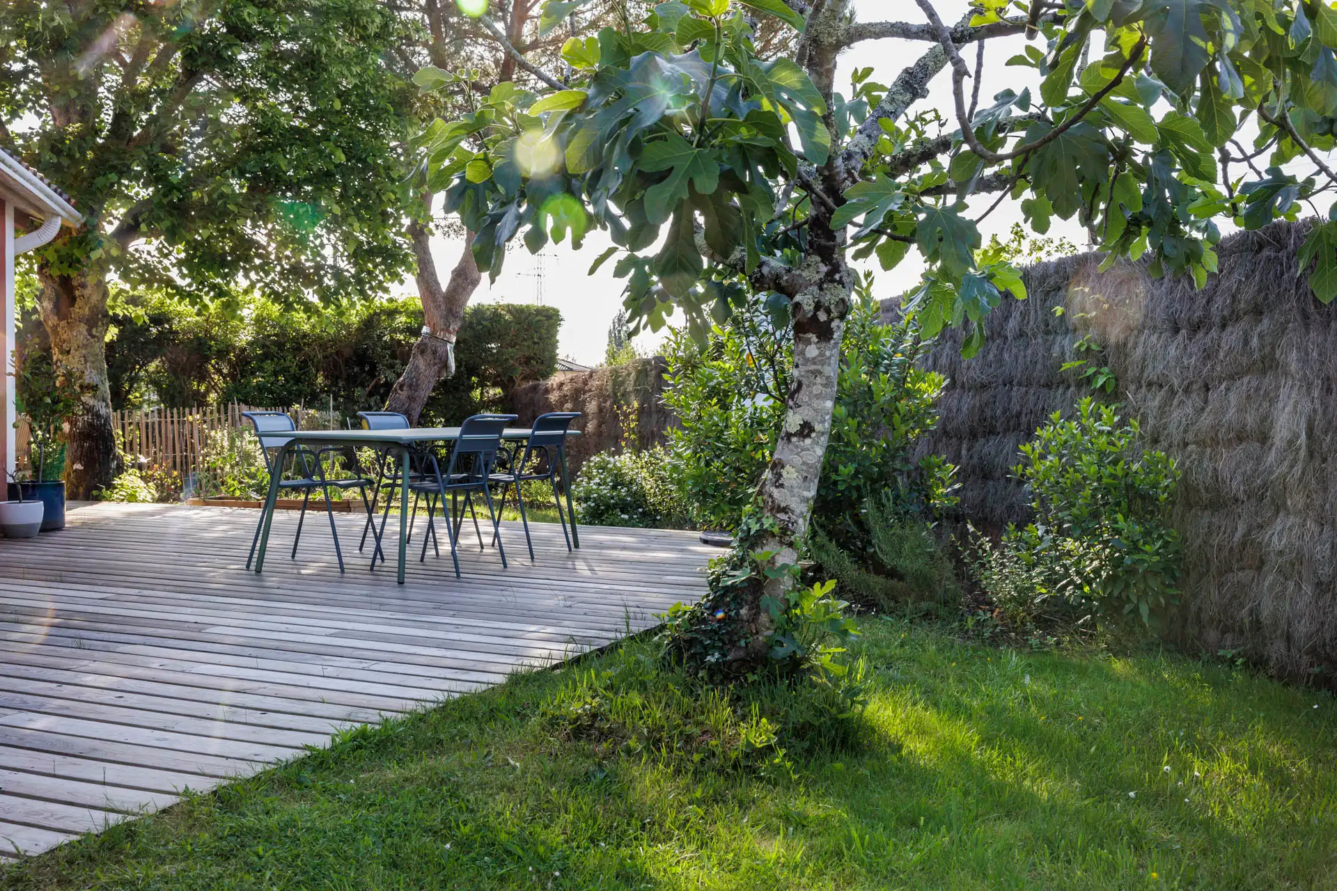 Terrasse en bois et massifs plantés d’un jardin réalisé à Léognan